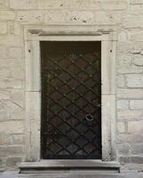 Very old solid door in brick stone wall of castle or fortress of 18th century photo