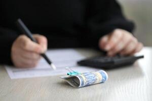 Accountant start to fill Iranian tax form on office table. Taxation period and annual taxpayers routine photo