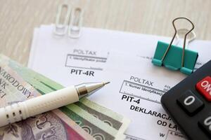 anual declaración de ingresos impuesto avances, hoyo-4r formar en contador mesa con bolígrafo y polaco zloty dinero cuentas foto
