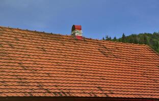 The roof of this square ceramic tile is red. The old type of roof covering in rich houses of the 19th century photo