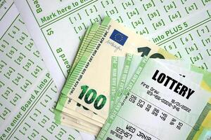 Green lottery tickets and euro money bills on blank with numbers for playing lottery photo