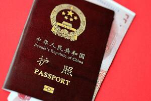 Red passport of People Republic of China and chinese yuan money bills. PRC chinese passport photo