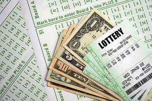 Green lottery tickets and US money bills on blank with numbers for playing lottery photo
