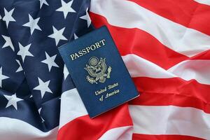 Blue United States of America passport on national flag background close up photo