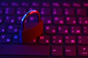 Computer security concept with a closed padlock on the keyboard. Padlock on top of a laptop keyboard. Selective focus photo