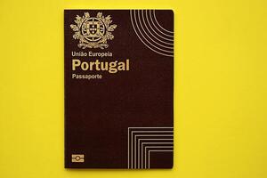 Red Portugal passport of European Union on yellow background close up photo