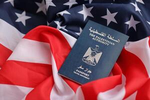 Blue Palestinian Authority passport on United States national flag background close up photo