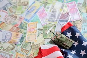 Tank on United States flag on many banknotes of different currency. Background of war funding photo