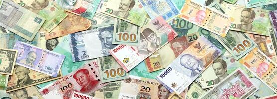 Many banknotes of different currency. Background of big amount of random money bills photo