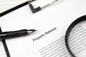 Property Release on A4 tablet lies on office table with pen and magnifying glass photo