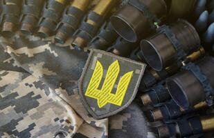 Ukrainian army symbol on machine gun belt lies on ukrainian pixeled military camouflage photo