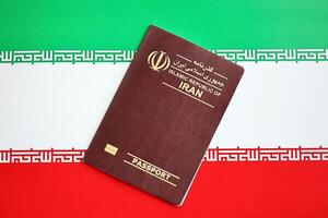 Red Islamic Republic of Iran passport on national flag background close up photo