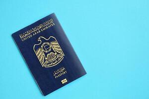 Blue United Arab Emirates passport on blue background close up photo