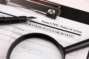 I-797c Notice of action blank form on A4 tablet lies on office table with pen and magnifying glass photo