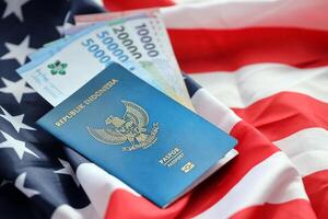 Blue Republic Indonesia passport and money on United States national flag background photo