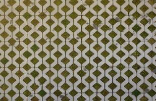 Geometric background of eco floor bricks and green grass. Eco parking texture. Floor stone tile with a rhomb hole for grass. Eco-friendly parking of concrete cells photo