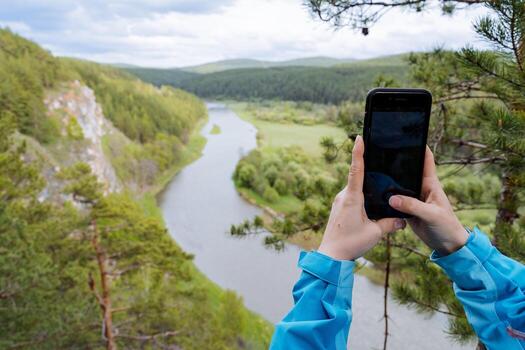 un persona fotografias un paisaje en un teléfono, De las mujeres manos sostener un teléfono inteligente mientras tomando un autofoto, hermosa naturaleza en un célula teléfono lente. foto