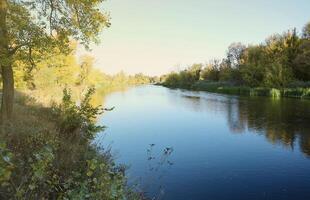 Beautiful autumn landscape with lake and multicoloral trees. Picturesque place with lake and tall trees photo