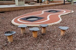 para niños patio de recreo en el ciudad parque, pasos para saltando, trampolines oculto en el asfalto, caucho pavimento de el camino, madera virutas de castigo. foto