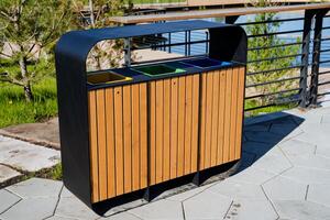 A garbage collection tank on the street, a clean container for household waste, throwing garbage into an urn in the park, the design of a city park, waste boxes. photo