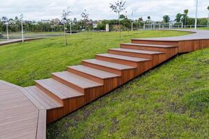 Wooden steps in the city park, a beautiful place to relax and walk in nature, a staircase of boards, the landscape of the park design of the territory. photo