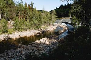 Panorama of a mountain river in the taiga, a rocky channel, a protected river bank fortified with concrete, the Inzer River in Bashkortostan Russia photo