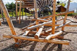 Children's playground, an obstacle made of logs, a city park for games, a labyrinth of trees. photo
