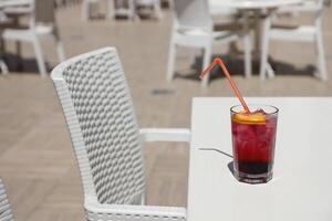 Pink and red Fresh colorful exotic alcoholic cocktail with lemon and ice on restaurant table. Colorful pink Soft drink with ice photo