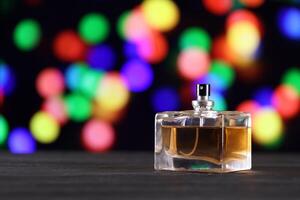 Women fragrance perfume bottle on dark festive background close up. Unnamed blank sprayer bottle of perfume photo