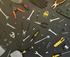 Handyman tool kit on black wooden table. Many wrenches and screwdrivers, pilers and other tools for any types of repair or construction works. Repairman tools photo