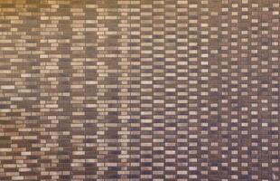 Dark brick wall pattern with chaotic masonry order. Background texture or resource for 3d texturing. Many bricks in big modern stone wall photo