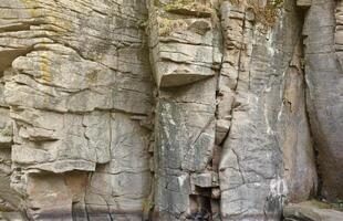 Light coarse natural rock stone background. Mining cliff rough front surface. Big limestone stack backdrop. Heavy grunge damaged granite block texture photo