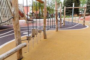 The children's sports complex is made of logs, a wooden playground in the city park, obstacles for children, the development of dexterity and coordination, safe playground coverage. photo