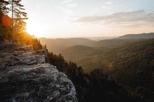 The evening sunset sun shines behind the mountain, the glare of the sun of beautiful color, the mountain landscape of the ridge of the southern Urals russia, the panorama at the top of the cliff. photo