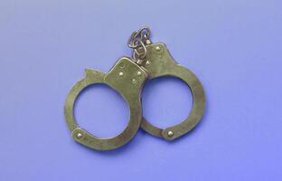 Bdsm and sex games concept. Handcuffs on blue background photo