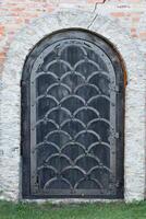 Very old solid door in brick stone wall of castle or fortress of 18th century photo