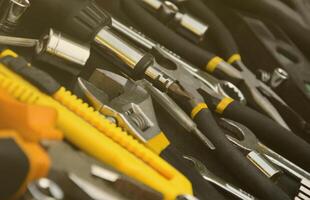 Handyman tool kit on black wooden table. Many wrenches and screwdrivers, pilers and other tools for any types of repair or construction works. Repairman tools photo