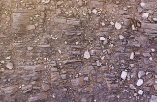 antecedentes de destrozado pedregoso piedras superficie en montaña área. textura con natural ligero foto