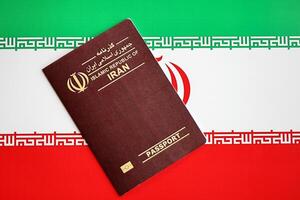 Red Islamic Republic of Iran passport on national flag background close up photo