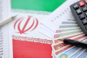 Iranian business calculations on table with iranian money and pen photo