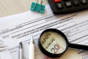 Declaration of the amount of earned income or incurred loss and corporate income tax, CIT-8 tax forms on accountant table with pen and polish zloty money bills photo