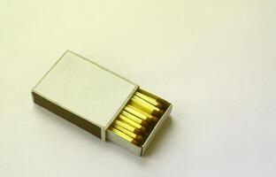 Open cardboard matchbox filled with matches on a white background photo