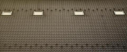 The texture of the roof with a roof made of metal, covered with drops from the rain. Several pane windows are built into the roof photo