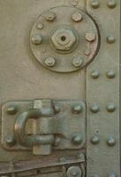 The texture of the wall of the tank, made of metal and reinforced with a multitude of bolts and rivets. Images of the covering of a combat vehicle from the Second World War photo