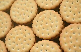 Detailed picture of round sandwich cookies with coconut filling. Background image of a close-up of several treats for tea photo