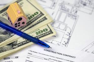 Residential construction agreement ready to sign with small toy houses and pen. Construction contract photo