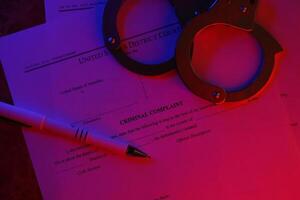 District Court Criminal complaint court papers with handcuffs and blue pen on table photo