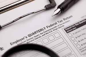 IRS Form 941-SS Employer's quarterly federal tax return blank on A4 tablet lies on office table with pen and magnifying glass photo