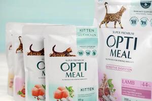 KHARKIV, UKRAINE - JANUARY 2, 2021 Optimeal cat meal packs. Optimeal is product by Kormotech LLC, a global family company, the largest producer of pet food in Ukraine photo