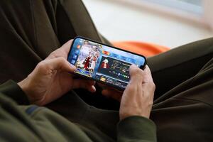 Fate Grand Order mobile iOS game on iPhone 15 smartphone screen in male hands during mobile gameplay photo